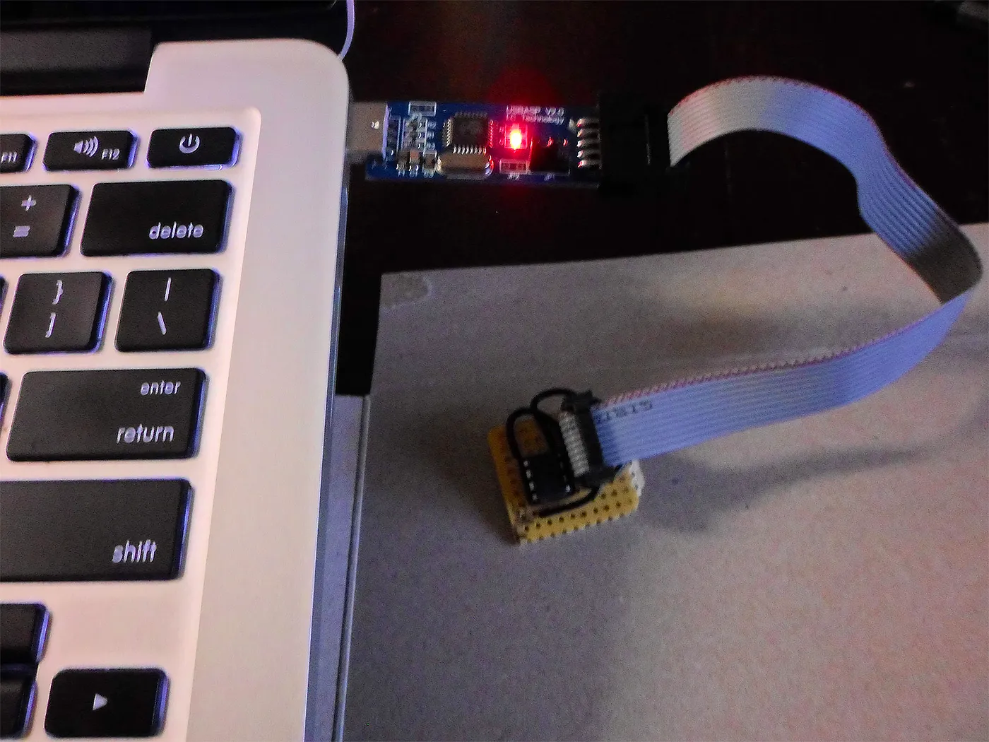 A USB programmer flashing a small circuit board